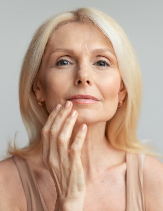 Portrait of mature woman touching lips with finger, beautiful aged lady enjoying self-care routine